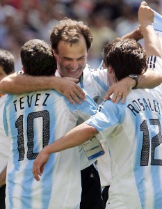 Bielsa celebra la medalla dorada en Atenas con Tevez y Rosales. Foto de Antonio Scorza / Foto AFP